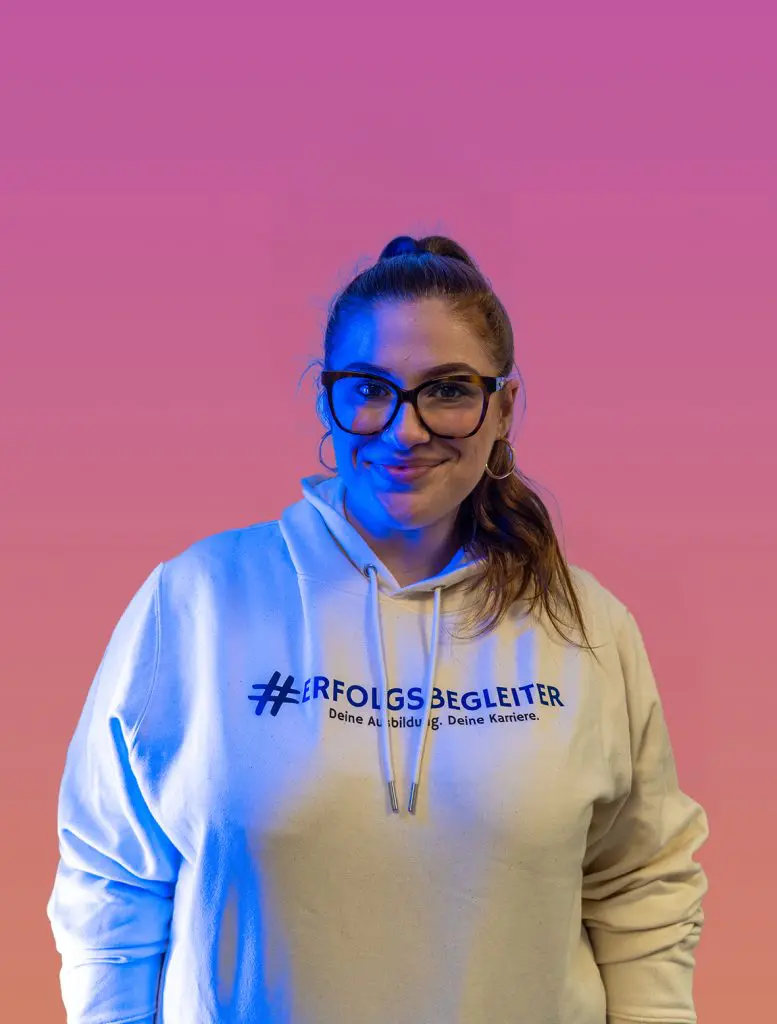 Arianna, ProTec Karrierebotschafterin, lächelt. Hoodie mit #ERFOLGSBEGLEITER. Unternehmen Karriere.