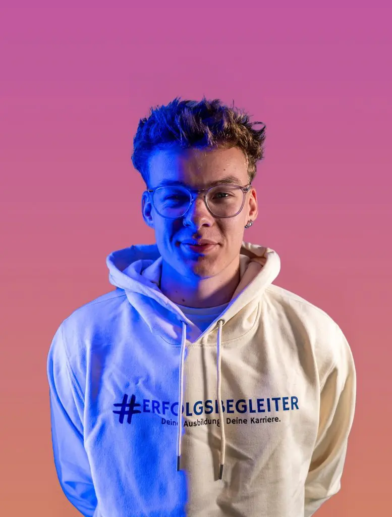 Timo_Bergmann Startseite: Porträt von Timo Bergmann mit Brille und Hoodie #ERFOLGSBEGLEITER.