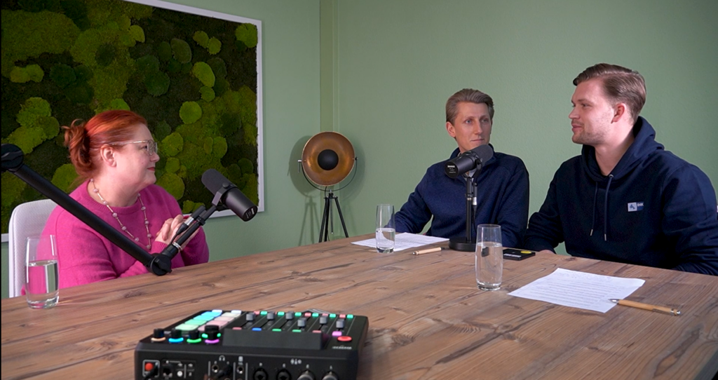 Foto_Homepage.png: Drei Personen am Tisch, Mikrofone, Podcast-Aufnahme zum Thema Verkauf und Marketing.